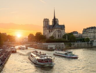 Katedra Notre Dame de Paris ze statkiem wycieczkowym na Sekwanie w Paryżu we Francji. Piękny zachód słońca w Paryżu Francja