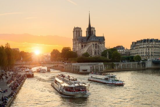 Katedra Notre Dame de Paris ze statkiem wycieczkowym na Sekwanie w Paryżu we Francji. Piękny zachód słońca w Paryżu Francja