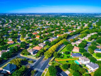 Setki domów wzdłuż zakrzywionych nowoczesnych dróg nowego przedmieścia na północ od Austin w Round Rock, Teksas, USA widok z lotu ptaka nad przedmieściem suburbia społeczność sąsiedzka