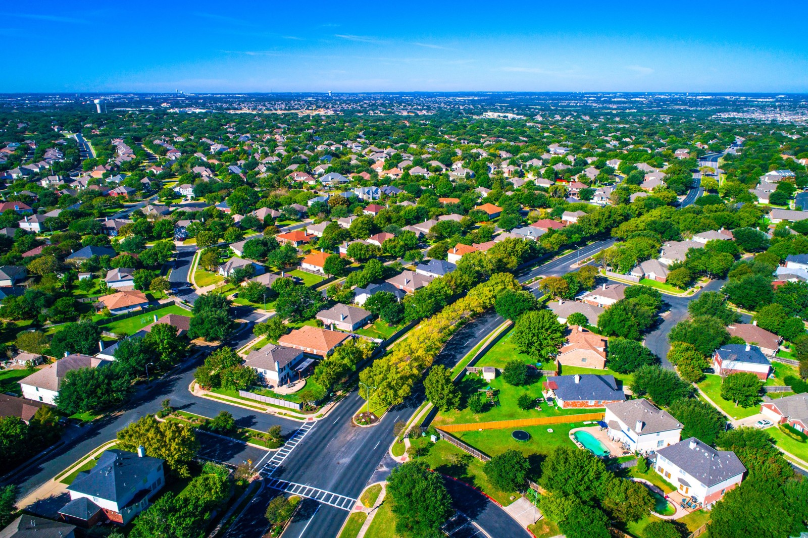 Setki domów wzdłuż zakrzywionych nowoczesnych dróg nowego przedmieścia na północ od Austin w Round Rock, Teksas, USA widok z lotu ptaka nad przedmieściem suburbia społeczność sąsiedzka