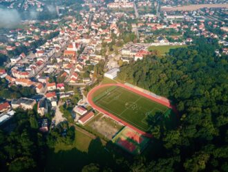 Widok z lotu ptaka na małe europejskie miasto z stadionem i boiskiem sportowym