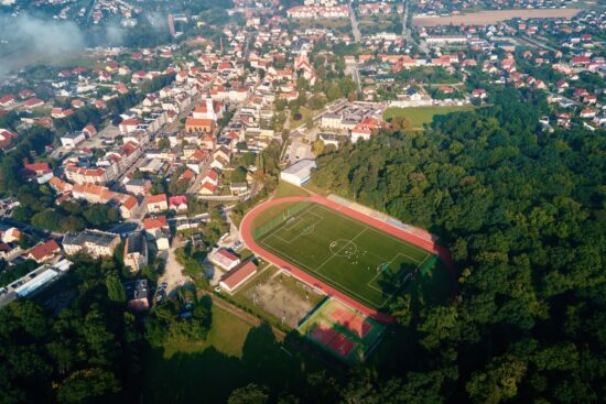 Widok z lotu ptaka na małe europejskie miasto z stadionem i boiskiem sportowym