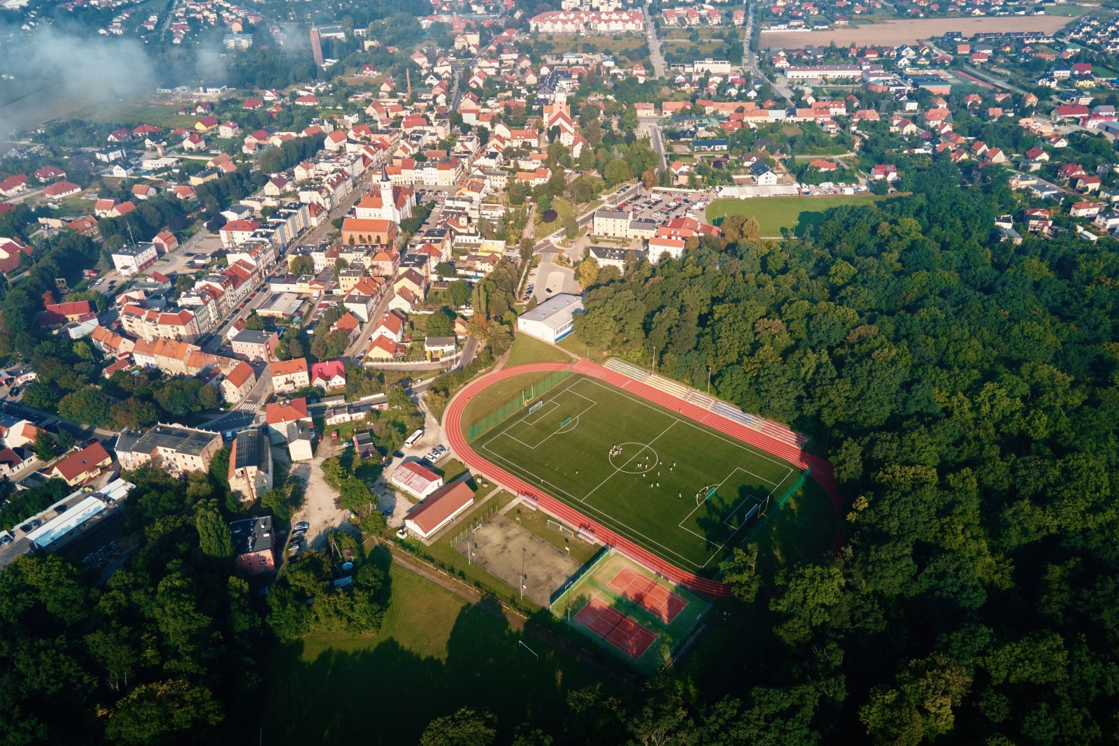 Widok z lotu ptaka na małe europejskie miasto z stadionem i boiskiem sportowym